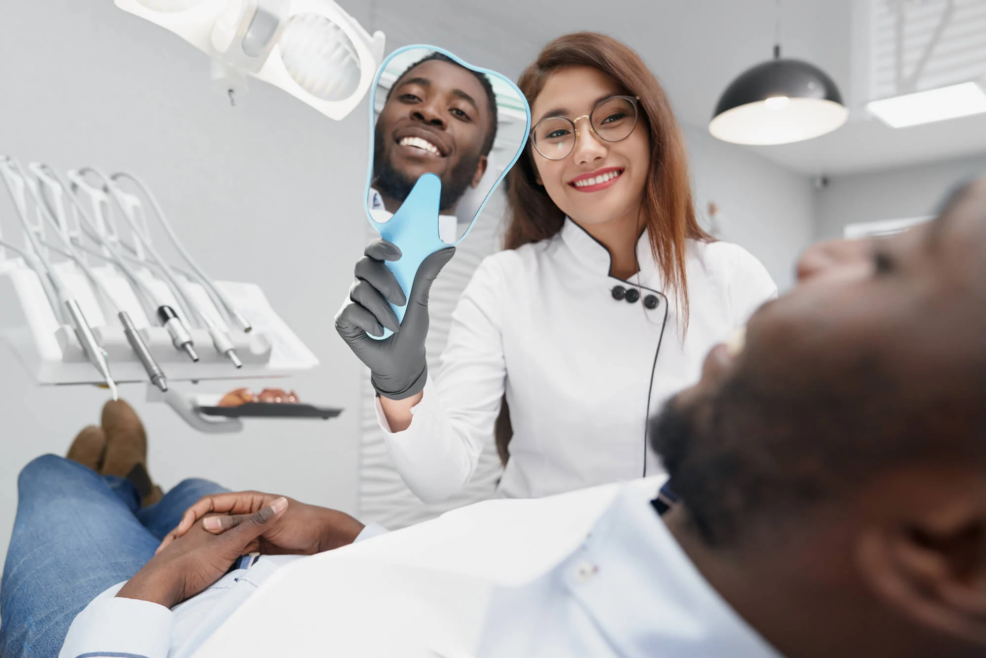 dentist holds mirror for patient after cosmetic dentistry in montgomery al