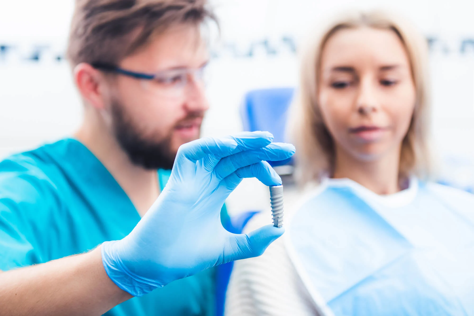 dentist showing patient a sample of all on four dental implants