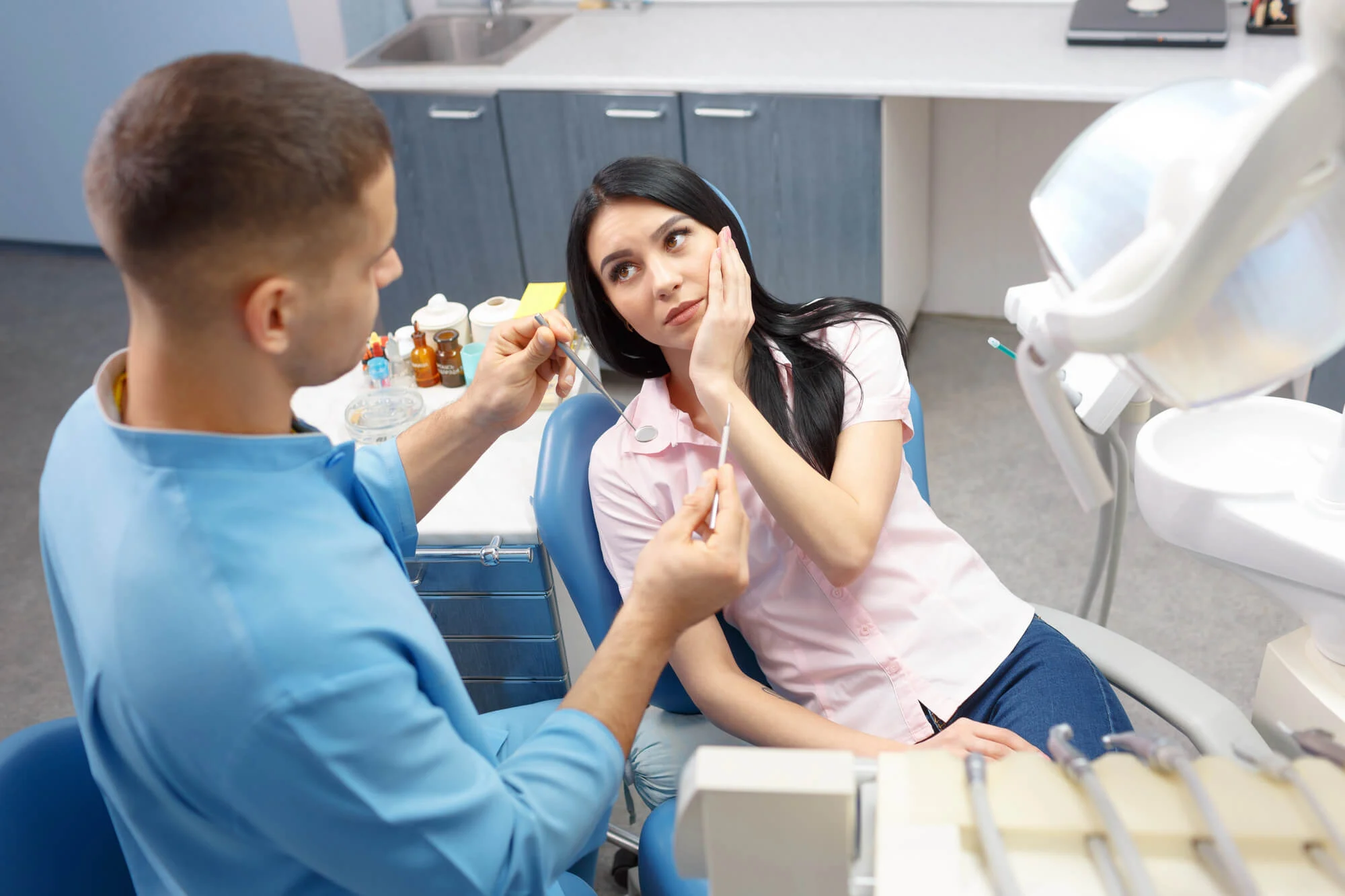 woman with dental pain asking about tooth extraction cost Alabama