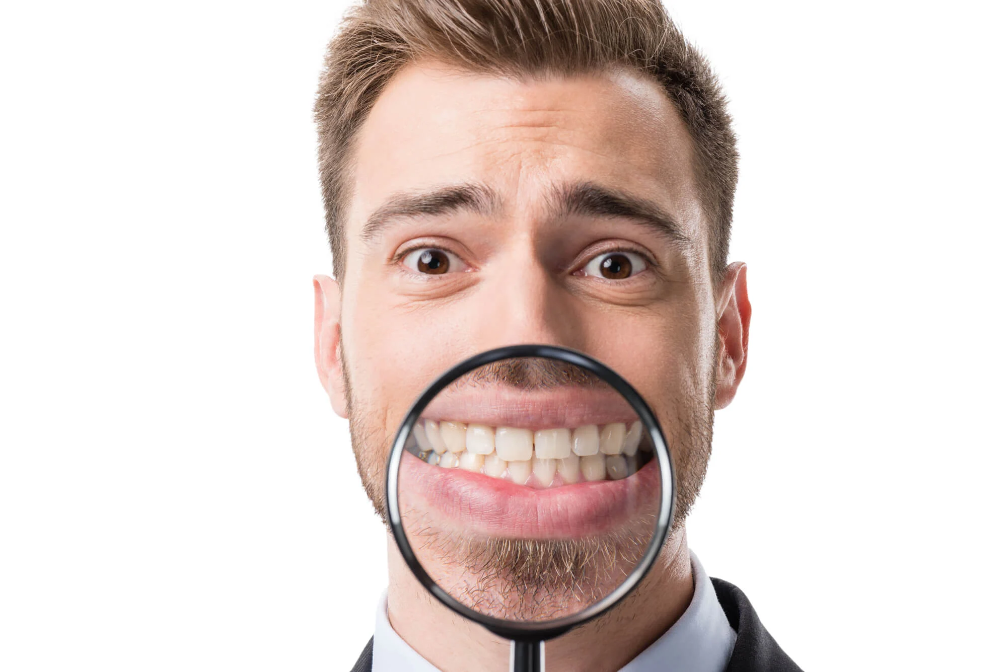 magnifying glass on man's tooth teeth whitening Montgomery AL