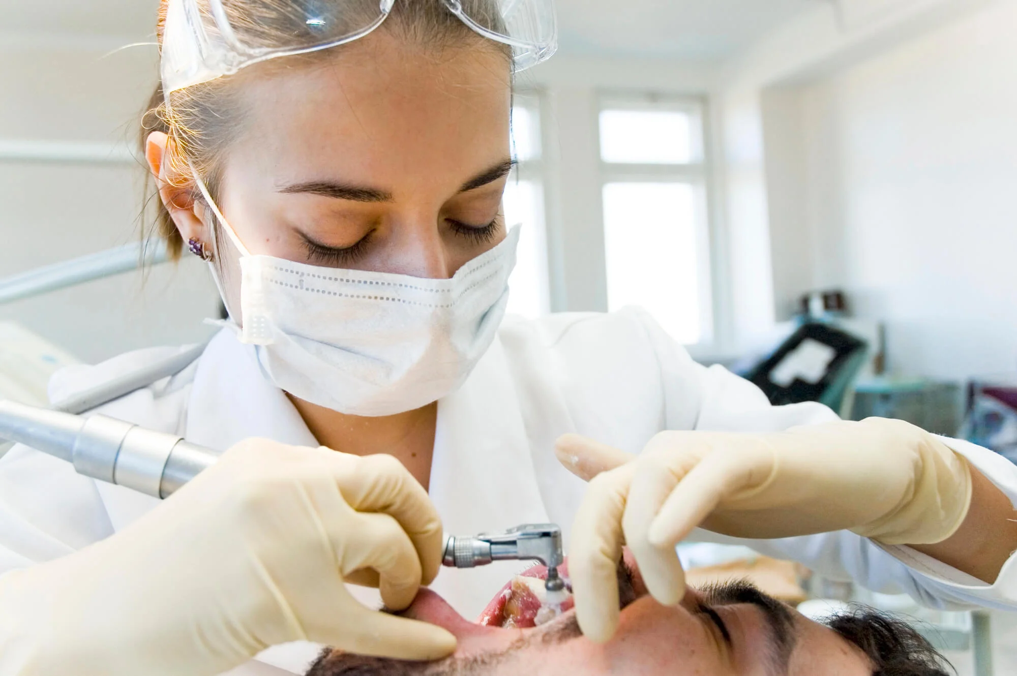 Dentist treating patient during procedure, good dental implants near you